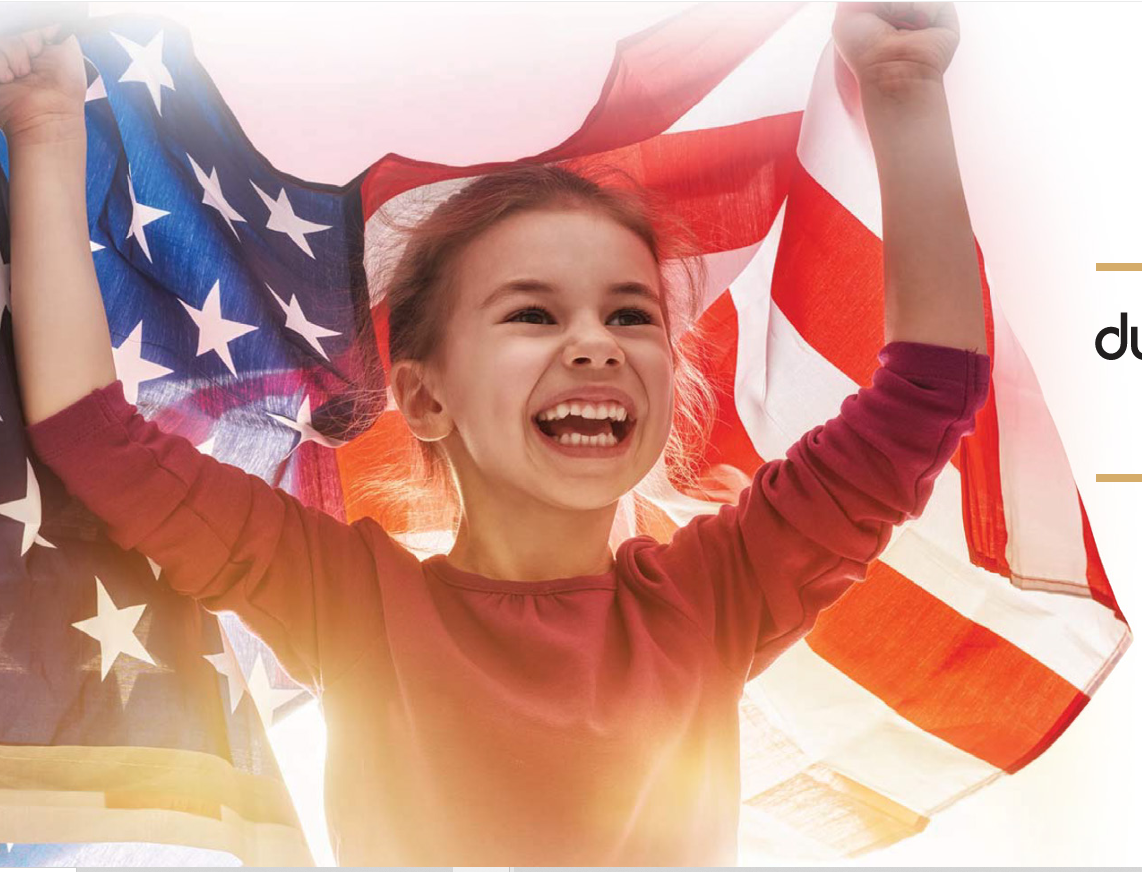 Smiling child holding an American flag overhead
